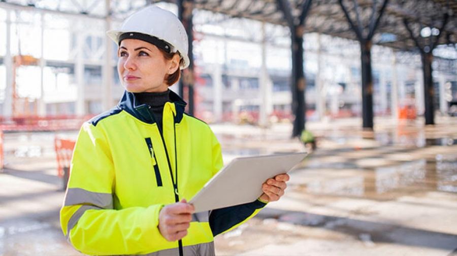 Engineer checking a report on a tablet at site